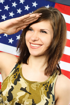 cheerful woman dressed in camouflage salutes