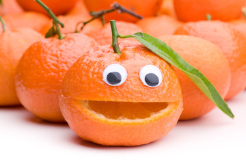 Mandarine mit Gesicht vor einigen anderen Mandarinen