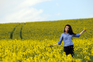 Naklejka na ściany i meble beautiful girl in a wild mustard field