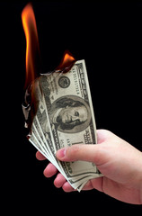 Burning dollars in a hand