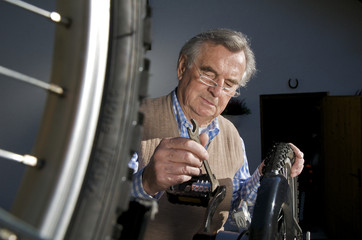 Aktiver Senior bei der Fahrradreparatur