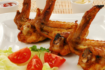 Grilled chicken wings with baked potatoes and vegetable salad