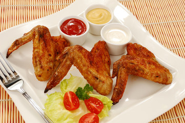 Grilled chicken wings with baked potatoes and vegetable salad