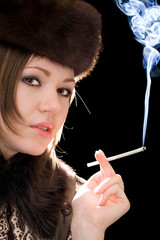 Obraz premium Portrait of the young woman with a cigarette