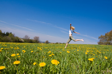 Naklejka na ściany i meble young female having fun on flowery meadow