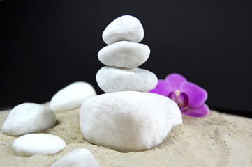 Fototapeta na wymiar Spa kamienie z orchidea na piaszczystych