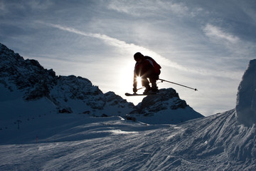 Skifahrer springt über eine Kuppe
