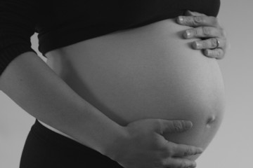 Caring hands on pregnant belly