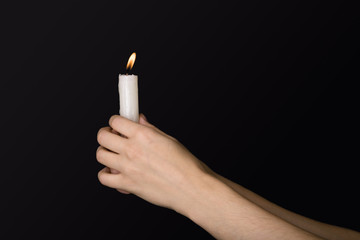 Burning candle in hands