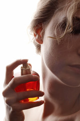 sensual woman applying perfume on her body