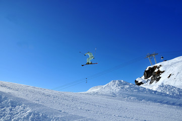 skier in white performing a high jump
