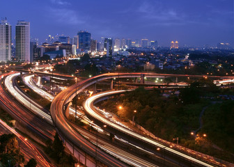 City skyline with multiple flyovers. Busy traffic light trails - 11817497