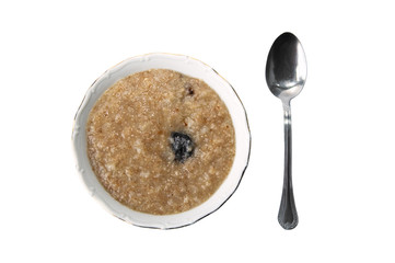 The spoon and a plate with a porridge