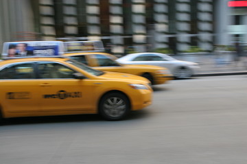 Fast driving yellow cabs (Taxi car) in Manhattan on Fifth Avenue, New York City, USA