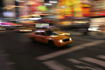 Fast driving yellow cab (Taxi car) in Manhattan at night on Times Square, New York City, USA