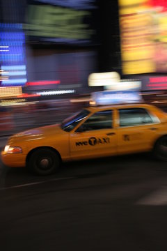Fast driving yellow cab (Taxi car) in Manhattan at night on Times Square, New York City, USA
