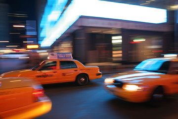 Fast driving yellow cabs (Taxi car) in Manhattan at night on Fifth Avenue, New York City, USA