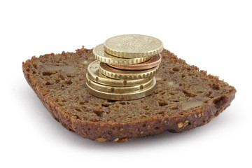 Fototapeta na wymiar Pyramid from coins on a slice of bread.