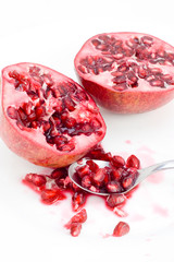 Halved fresh Pomegranate with seeds and spoon