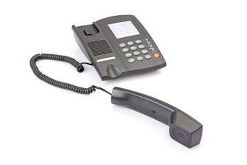 Black office telephone off hook isolated on white background.