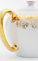 Ornate teapot handle with gold filigree and gold plate.