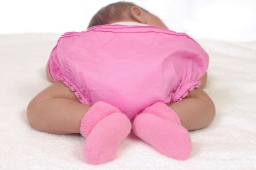 rear view of baby girl in pink bloomers, 3 weeks old