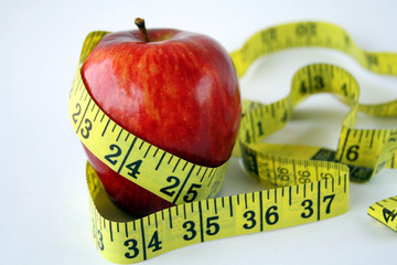 Apple with measuring tape around in white background