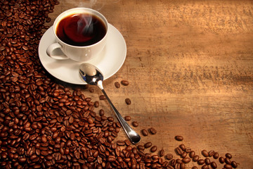 White coffee cup with beans on rustic  table
