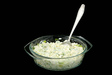 Vegetable salad in a glass plate on a black background