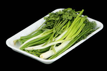 Vegetables in the plastic container on a black background