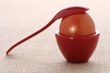 gilded red Easter egg in cup on ristic background