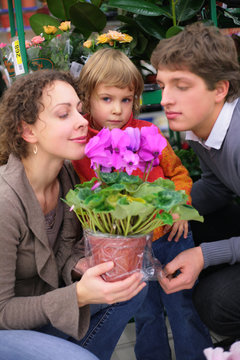 Parents and child with pot in flower shop