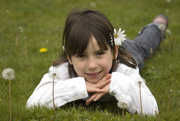 Young girl on a dandelion field
