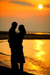 Couple silhouette on the beach at sunset