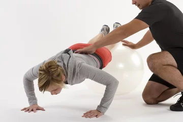 Fotobehang Woman exercising with personal trainer © edbockstock