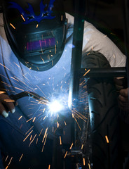 Welder working on motorcycle