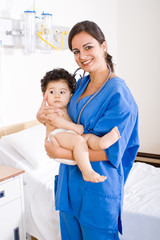 female nurse holding baby boy patient