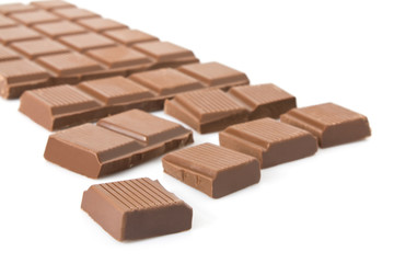 Broken milk chocolate bar isolated on white background