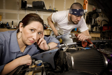 Bored woman with mechanic in background
