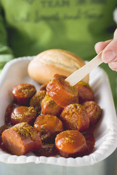 eating currywurst with wooden fork