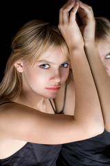 Fototapeta premium Portrait of the beautiful young blonde near a mirror