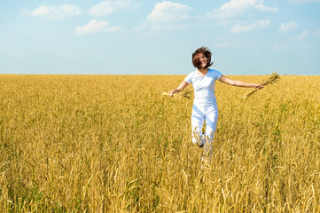 Girl in a white dress running on field.