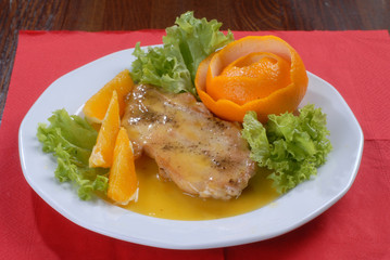 a plate of delicious juicy pork chop served with orange