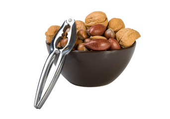 Nuts mix in brown plate and silver nutcracker