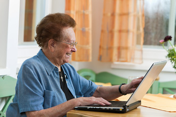 Aktive Seniorin mit Laptop in Freizeit