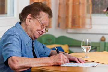 Seniorin unterschreibt einen Vertrag