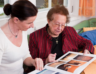 Seniorin blättert in Fotoalbum