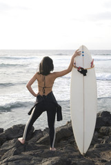 Pretty surfer girl waiting for waves under the sun