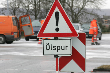 schild ölspur auf einer landstraße