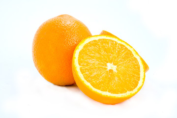A halved and whole orange isolated on white